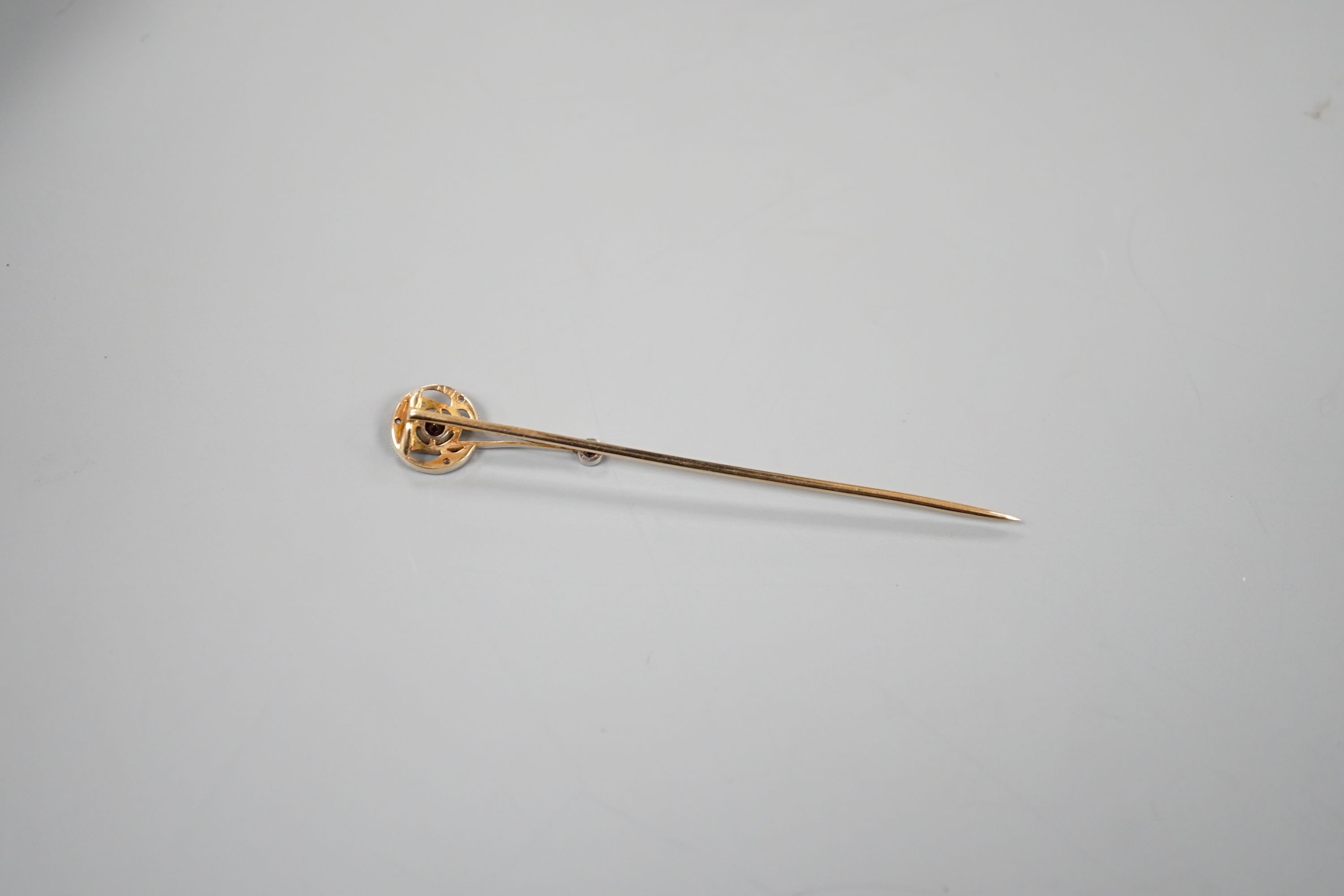 A cased American 14k, garnet and diamond chip set stick pin, by Shreeve & Company, 67mm, gross weight 2.3 grams.